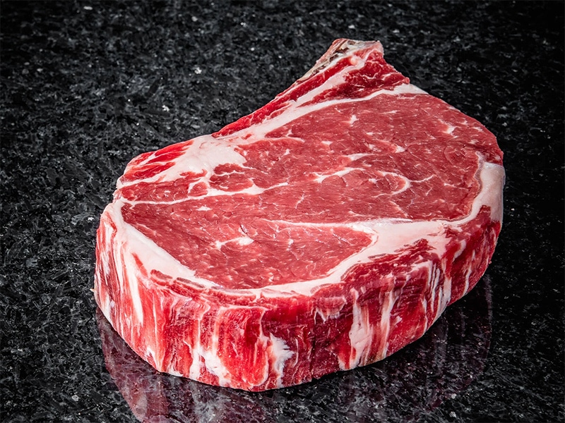 Fresh beef cuts on dark slate